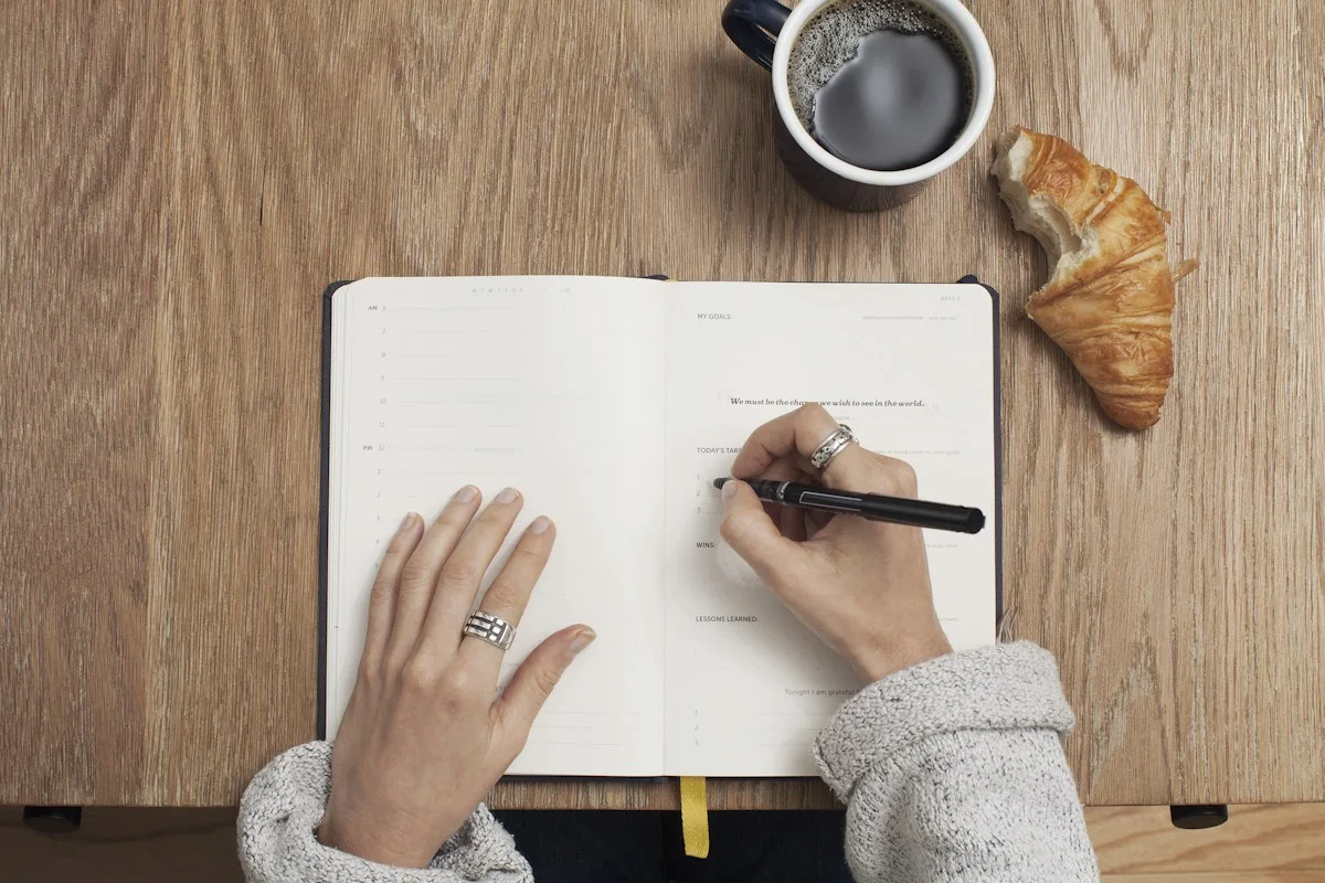 Una persona escribe y desarrolla ideas en un cuaderno